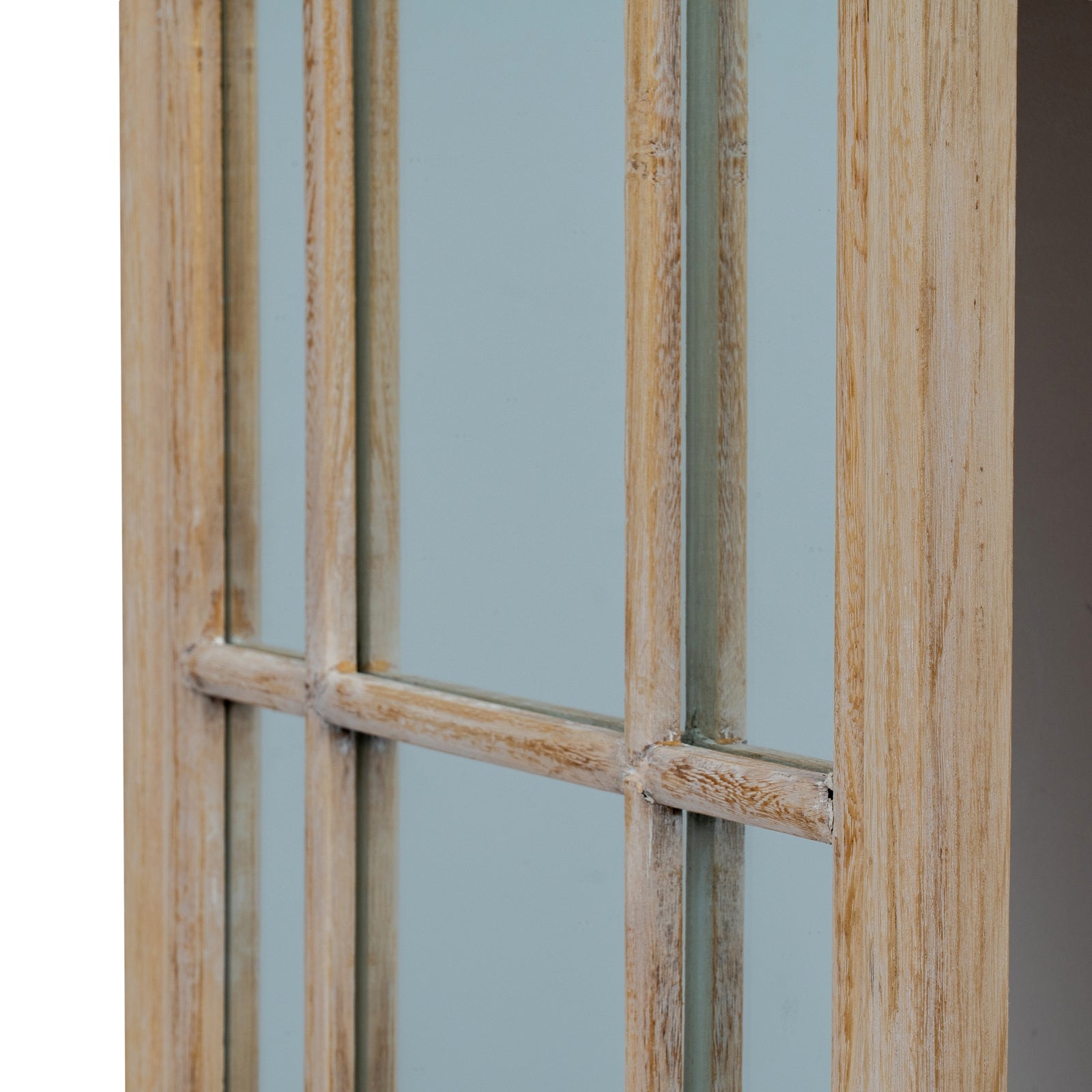 Wooden window frame with glass panes against a light blue wall