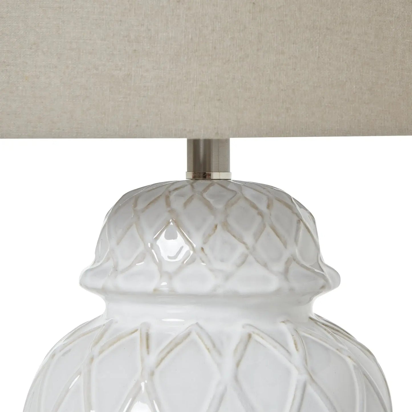 Close-up of a white textured lamp base with a beige lampshade on a white background