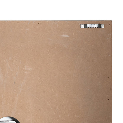 Back of a painting with a signature plate on a beige background