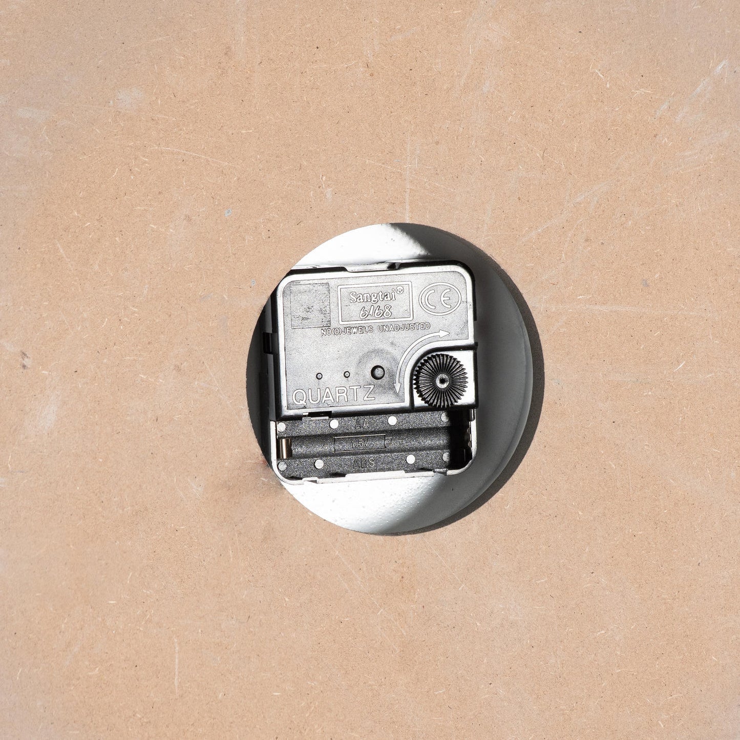 Vintage-style radio on a round metallic base against a beige background