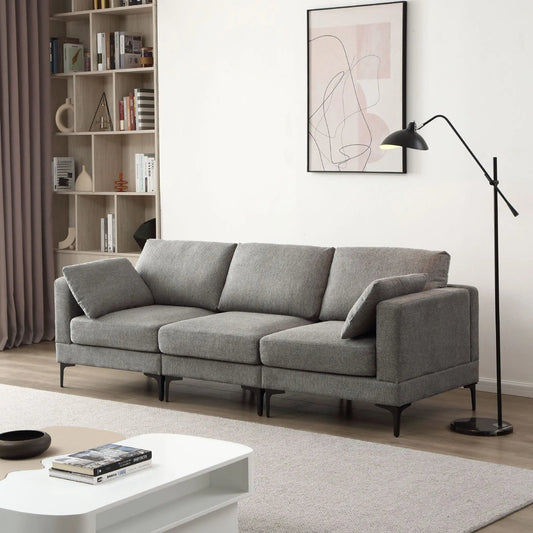 Gray sofa in a modern living room with a bookshelf and floor lamp.