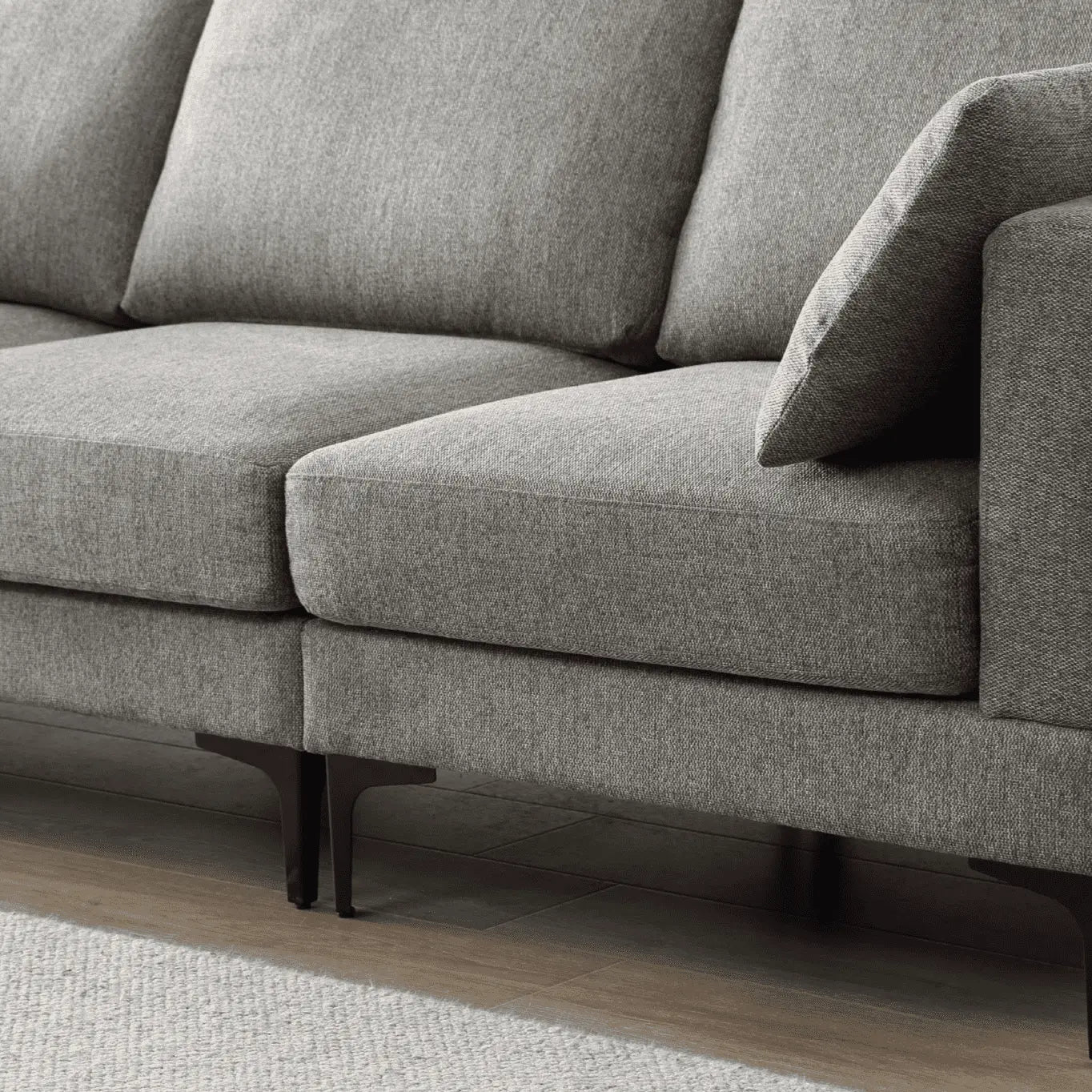 Gray sofa with wooden legs on a neutral background