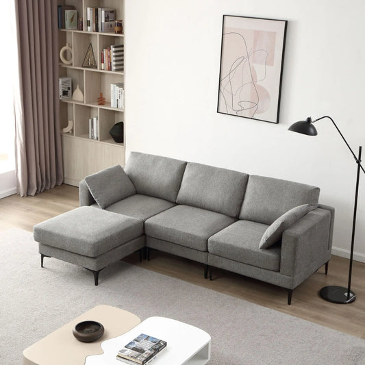 Gray sectional sofa in a living room with a bookshelf and lamp.