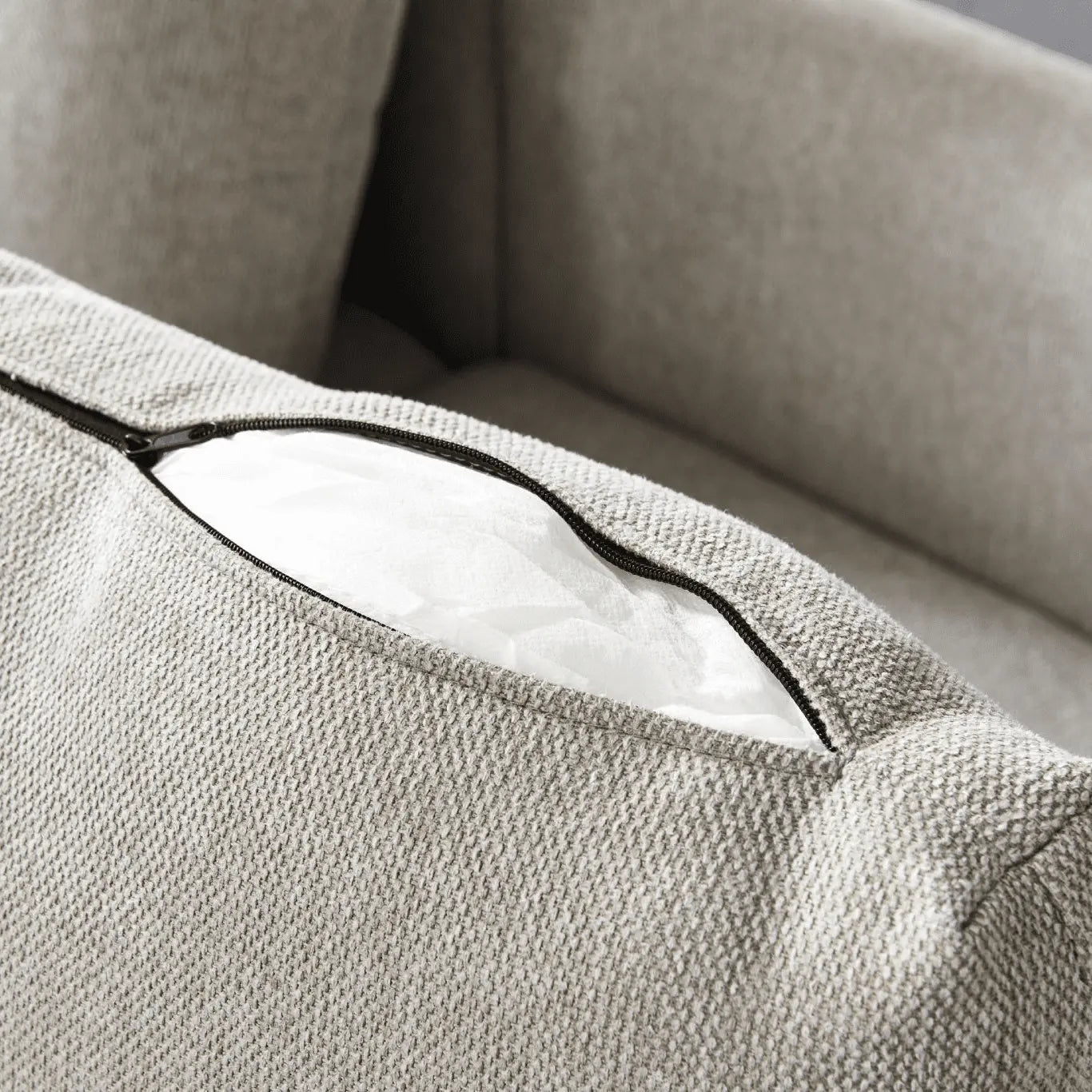 Close-up of a textured beige fabric surface with a zipper