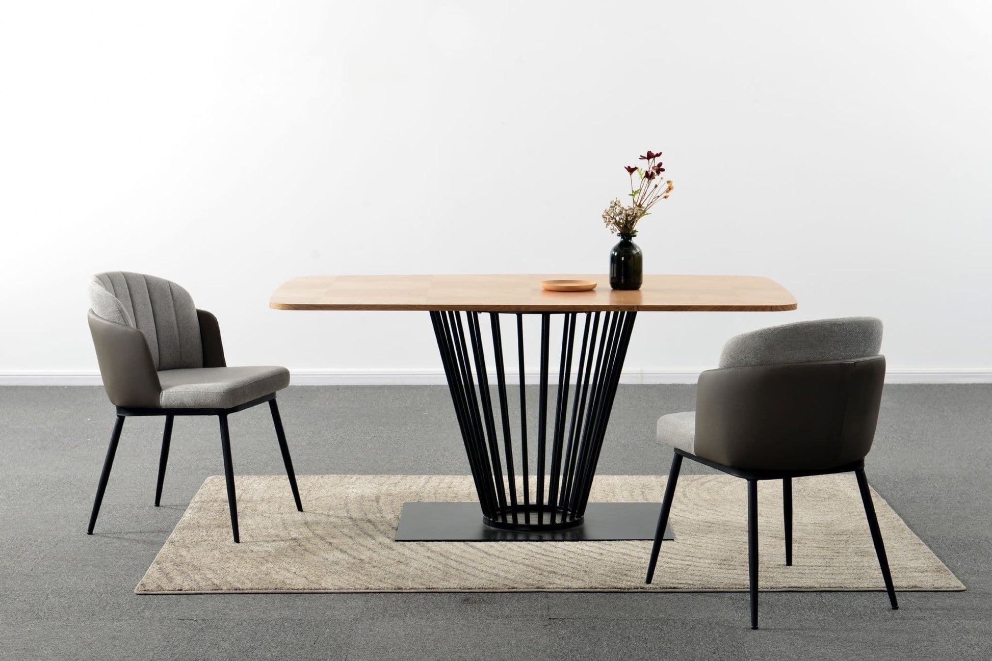 Modern dining table with two chairs on a gray floor and white wall background