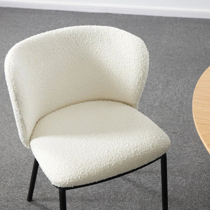 White textured chair on a gray floor with a wooden table corner.